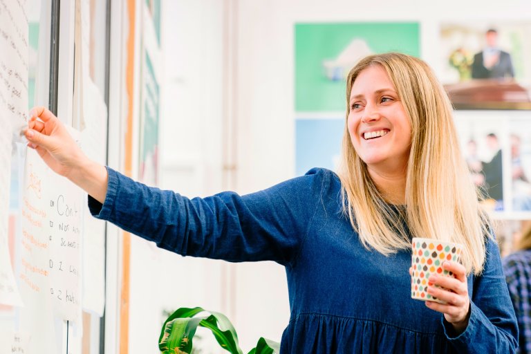 woman pinning paper on whiteboard